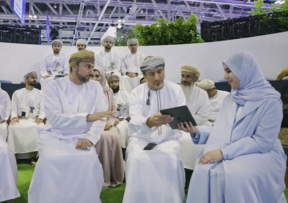 image of three people sitting passing an iPad